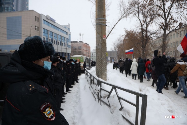 Полицейские плотной цепью стоят вдоль проезжей части. Участники акции идут по пешеходным тротуарам Полицейские плотной цепью стоят вдоль проезжей части. Участники акции идут по пешеходным тротуарам