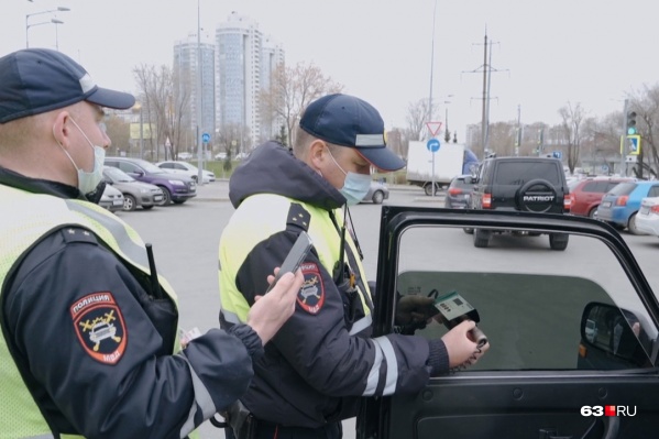 Дорожные полицейские проверяют светопропускную способность стекол специальным прибором Дорожные полицейские проверяют светопропускную способность стекол специальным прибором