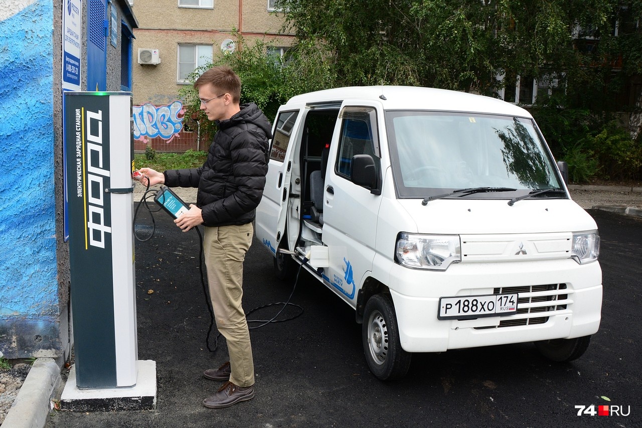 Алексей Рзянкин готовится зарядить свой электрический микроавтобус от терминала «Россетей» на пересечении улиц Университетской Набережной и Молодогвардейцев