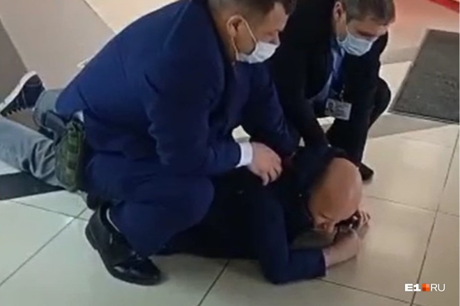 Мужчину повалили на пол двое охранников Мужчину повалили на пол двое охранников