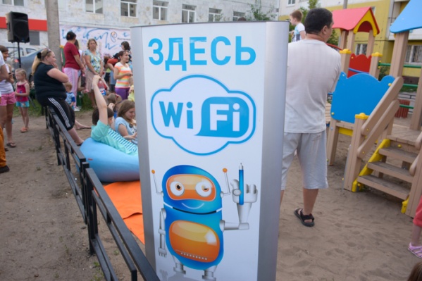 Прямо во дворе дома, на детской площадке, стоит большой телевизор. Малыши, усевшись вокруг него, смотрят мультфильмы по цифровому детскому каналу. Рядом уютные мягкие кресла, на которых сидят взрослые и ловят Wi-Fi Прямо во дворе дома, на детской площадке, стоит большой телевизор. Малыши, усевшись вокруг него, смотрят мультфильмы по цифровому детскому каналу. Рядом уютные мягкие кресла, на которых сидят взрослые и ловят Wi-Fi
