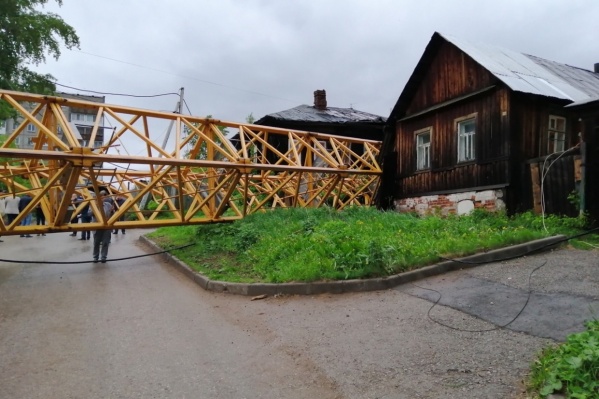 Упавший кран частично разрушил деревянный жилой дом, надворные постройки, примыкающие к ещё одному деревянному дому, и легковой автомобиль Упавший кран частично разрушил деревянный жилой дом, надворные постройки, примыкающие к ещё одному деревянному дому, и легковой автомобиль