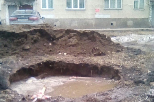 Огромная яма находится на детской площадке на улице Лейтенанта Амосова Огромная яма находится на детской площадке на улице Лейтенанта Амосова 