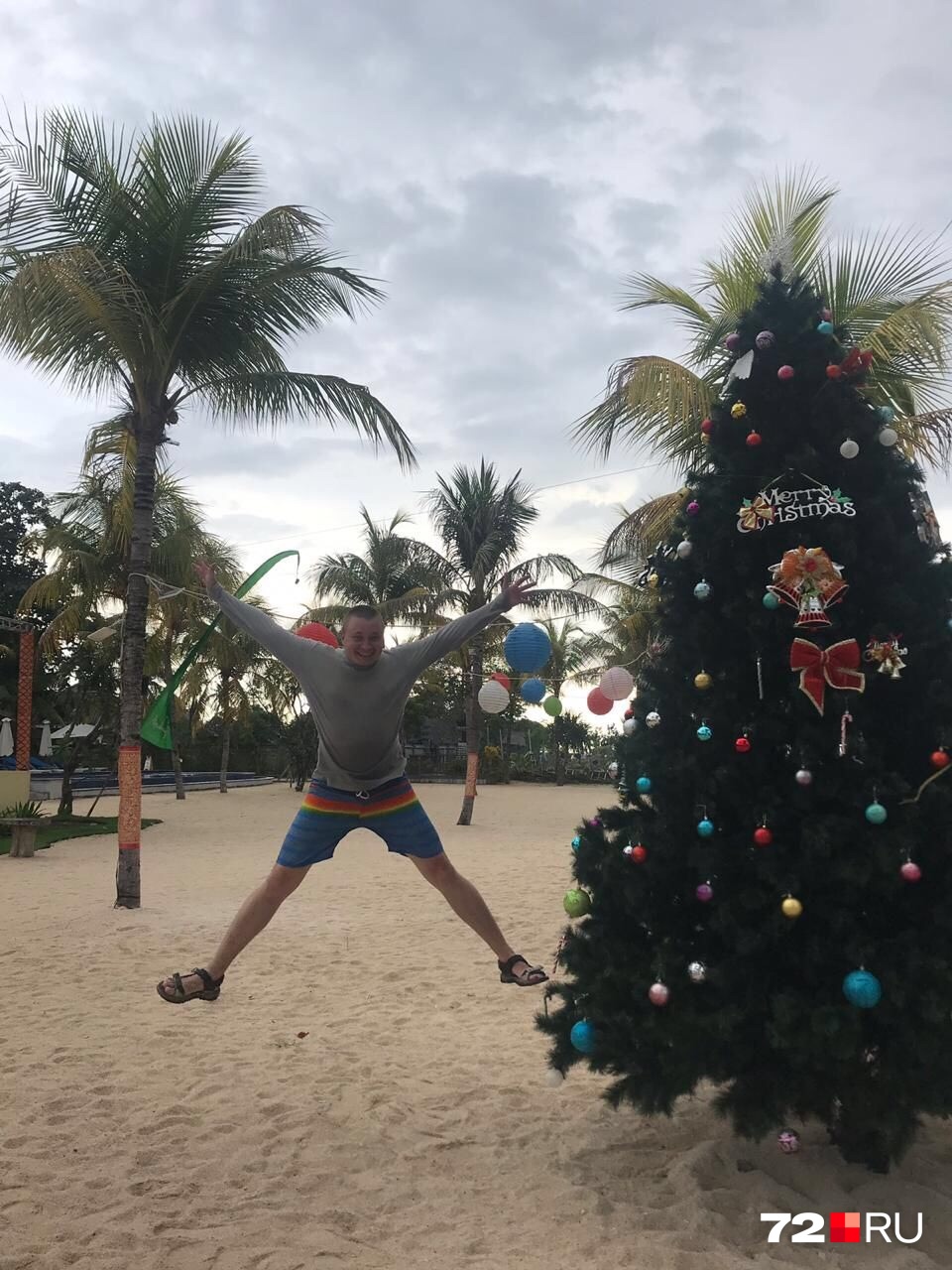 Согласитесь, непривычно наблюдать хвойное деревце в шарах и бантах на фоне пляжа и пальм