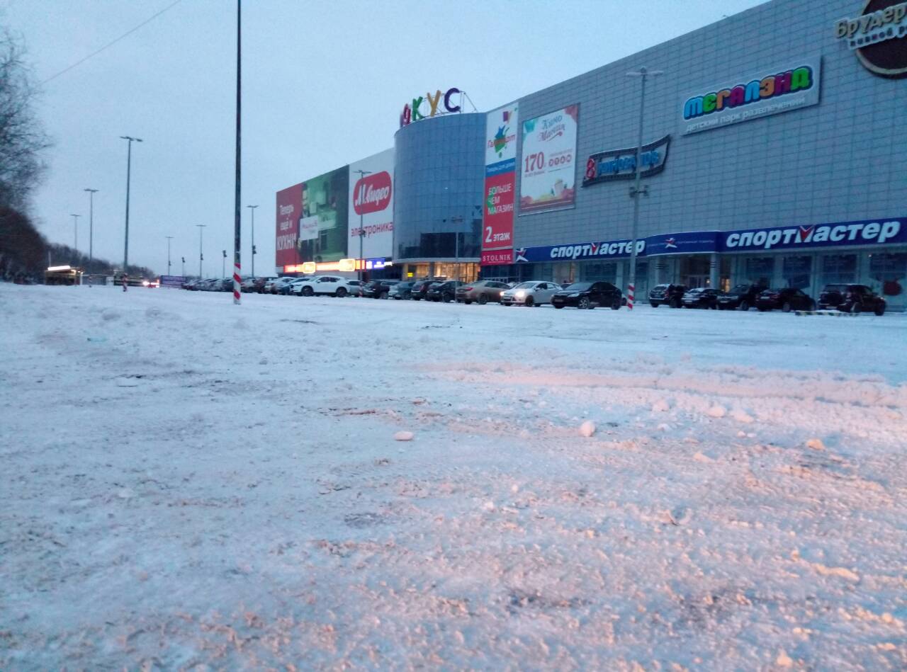 Парковка около торгово-развлекательного комплекса тоже пока в снегу
