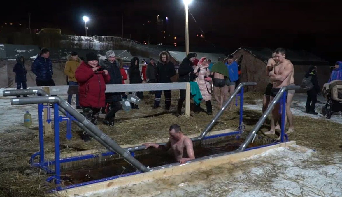 Мужчины стоят в очереди, чтобы искупаться в воде Мужчины стоят в очереди, чтобы искупаться в воде