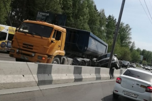 Внедорожник Infiniti застрял между отбойником и грузовиком Внедорожник Infiniti застрял между отбойником и грузовиком