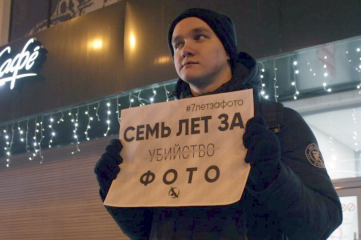 Молодые люди стояли с плакатом у ЦУМа Молодые люди стояли с плакатом у ЦУМа