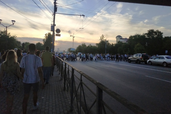 Люди идут прямо через улицу Люди идут прямо через улицу