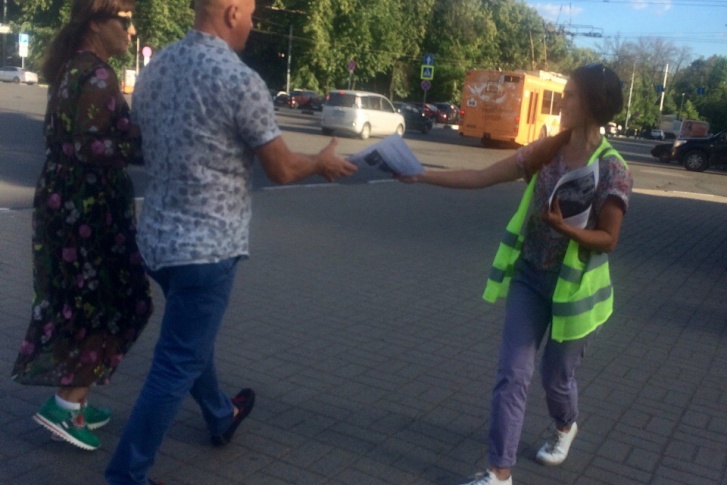 Прохожим раздают листовки Прохожим раздают листовки