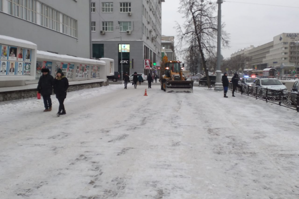 Трактор убирал снег в месте, где постоянно плотный людской поток Трактор убирал снег в месте, где постоянно плотный людской поток