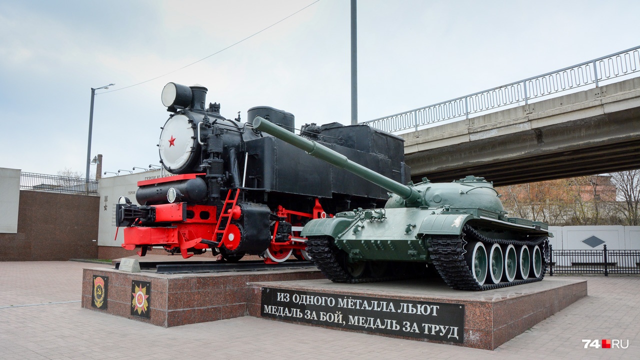 Паровоз 9П и танк Т-62 стоят около автомобильного моста рядом с железнодорожным вокзалом