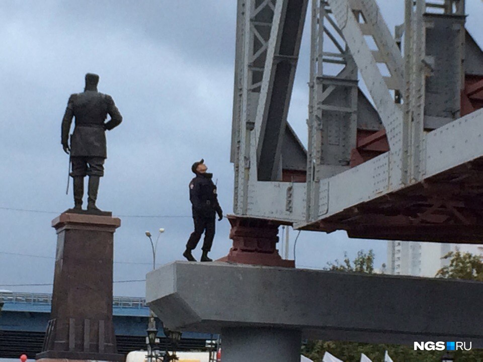 Полицейский готовится снять залезшего на памятник новосибирца. Фото Максима Гребенщикова Полицейский готовится снять залезшего на памятник новосибирца. Фото Максима Гребенщикова