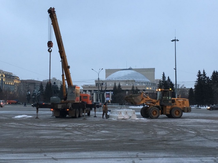Рабочие выгружали на парковку бетонные ограждения Рабочие выгружали на парковку бетонные ограждения