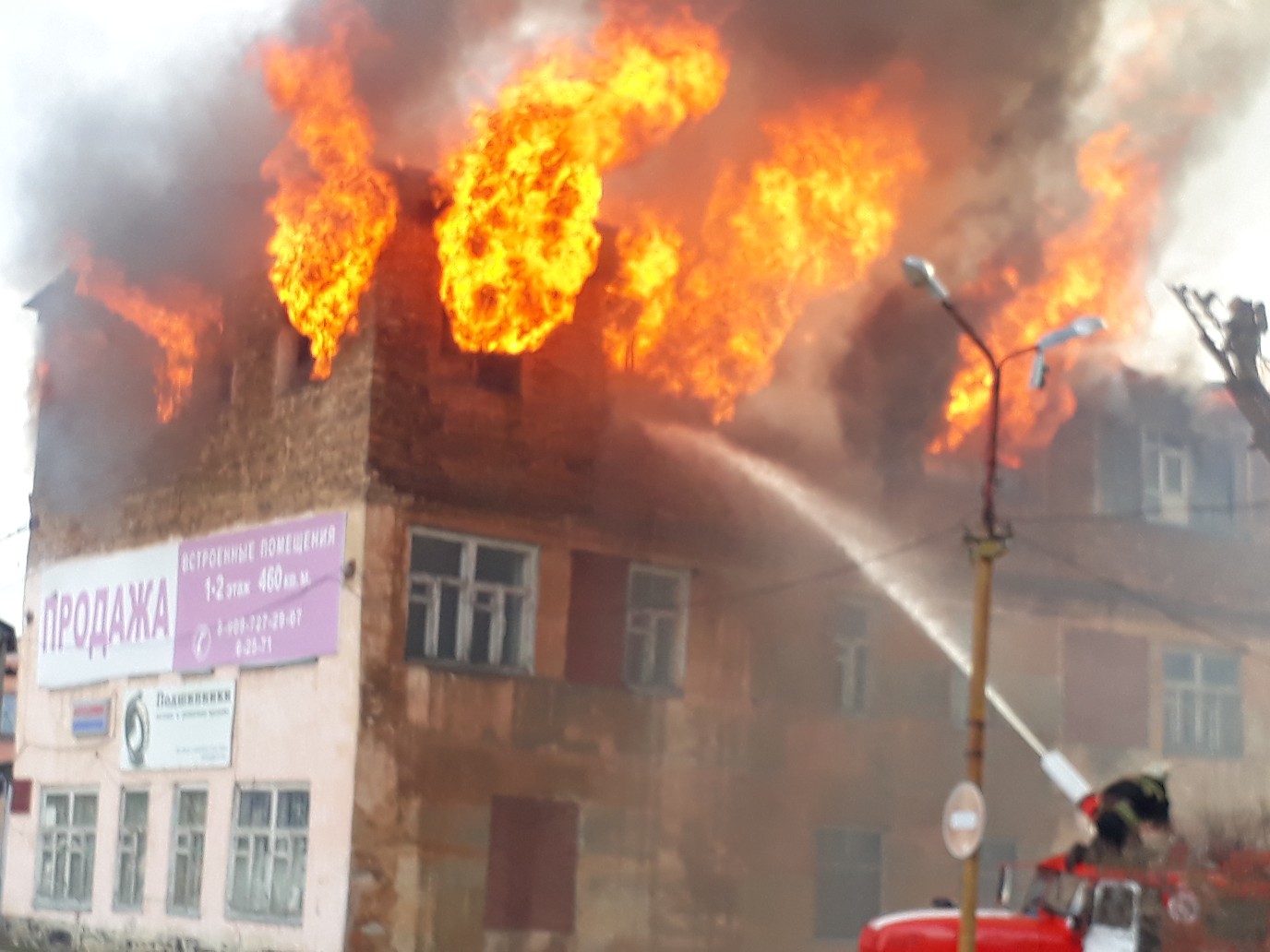 Пожарные пытаются потушить огонь на крыше 