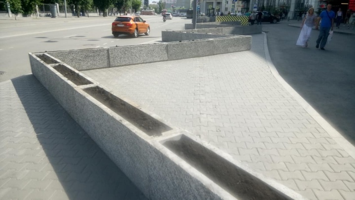 Мешающие пешеходам бетонные вазоны у «Гринвича» не убрали, но засыпали в них землю
