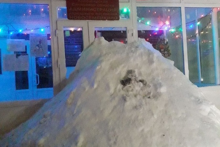 Огромная куча снега преградила вход в здание администрации