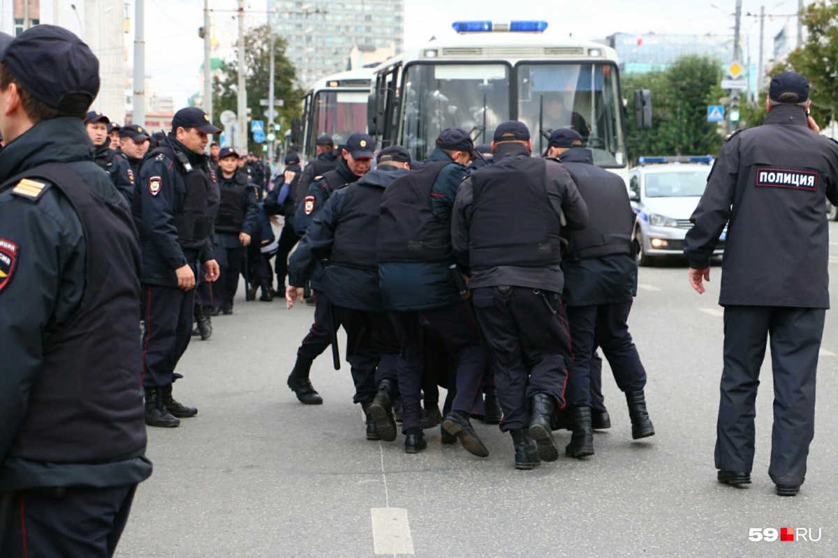 Полиция уводит, точнее, уносит задержанных в пазики