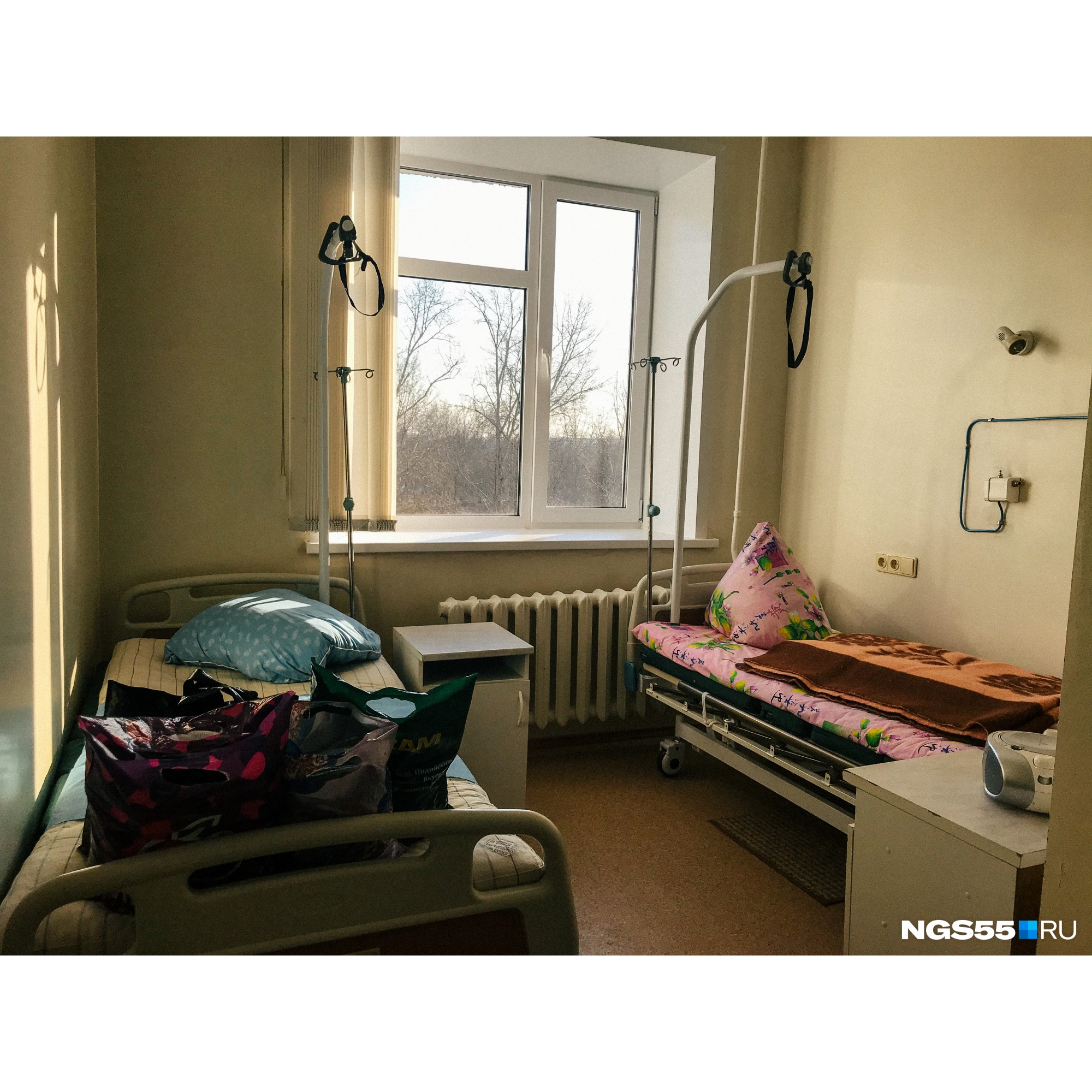 На кровати стоят пакеты с вещами — кто-то из омичей готовится заселиться в эту палату На кровати стоят пакеты с вещами — кто-то из омичей готовится заселиться в эту палату