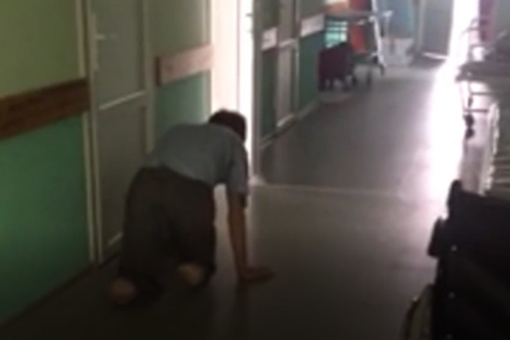 На видео мы видим мужчину без ног, который ползает по полу. Рядом — ни одного медработника На видео мы видим мужчину без ног, который ползает по полу. Рядом — ни одного медработника