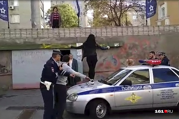 Одна из девушек забралась на патрульный автомобиль и прыгала на нем Одна из девушек забралась на патрульный автомобиль и прыгала на нем