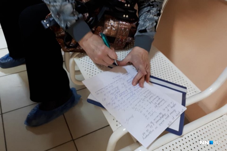 Люди подписывали письмо, сидя в очереди на прием Люди подписывали письмо, сидя в очереди на прием