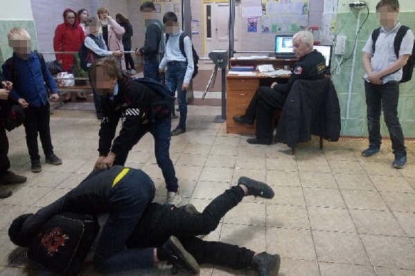 Пожилой охранник смотрел на драку между учениками Пожилой охранник смотрел на драку между учениками