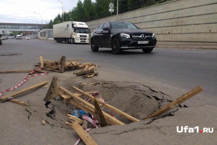 Водители завалили яму деревяшками Водители завалили яму деревяшками