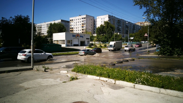 Разлившаяся по улице вода мешает проехать машинам Разлившаяся по улице вода мешает проехать машинам