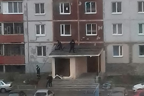 Тело мужчины лежало на козырьке подъезда жилого дома Тело мужчины лежало на козырьке подъезда жилого дома
