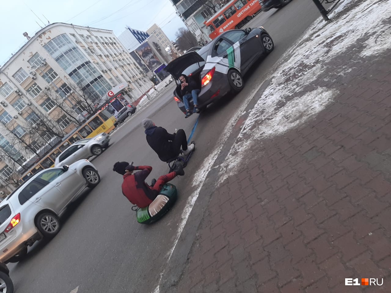 На проспекте Ленина парни на бублике и снегокате устроили покатушки, прицепившись к машине