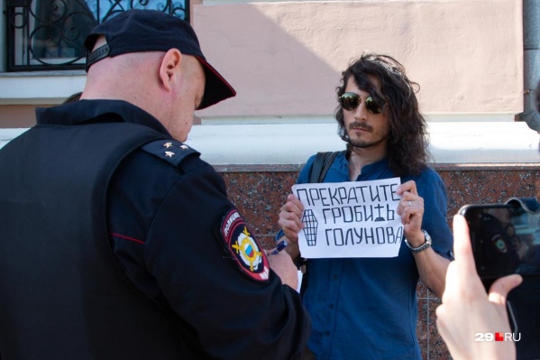 Полицейский переписывает паспортные данные Артема Келарева, который встал в одиночным пикетом Полицейский переписывает паспортные данные Артема Келарева, который встал в одиночным пикетом 