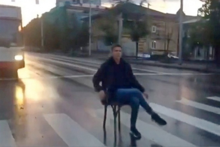 Молодой человек прихватил стул и отправился с ним на пешеходный переход Молодой человек прихватил стул и отправился с ним на пешеходный переход