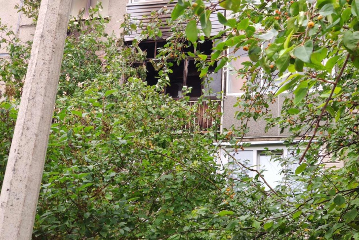Выбитые пожаром окна на балконе сгоревшей квартиры