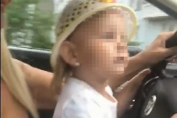 Держась за руль одной рукой, другой женщина снимала ролик, периодически давая порулить маленькой девочке 