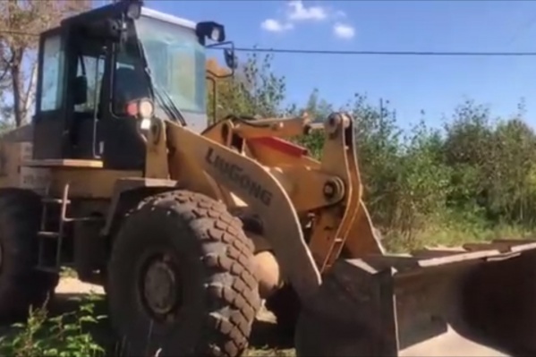 Этот грейдер приехал, чтобы выровнять землю под контейнерную площадку Этот грейдер приехал, чтобы выровнять землю под контейнерную площадку