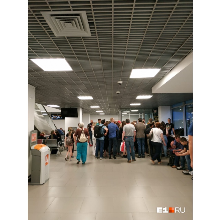 Люди выстроились в очередь, чтобы поставить отметки в посадочных талонах Люди выстроились в очередь, чтобы поставить отметки в посадочных талонах