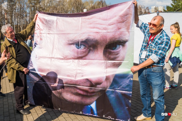 Большой баннер с президентом использовали в качестве подстилки, на которой можно сидеть Большой баннер с президентом использовали в качестве подстилки, на которой можно сидеть
