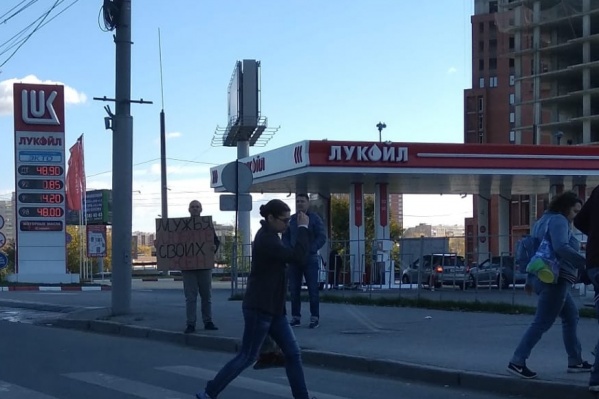 Прохожий стоял с плакатом на тротуаре Прохожий стоял с плакатом на тротуаре