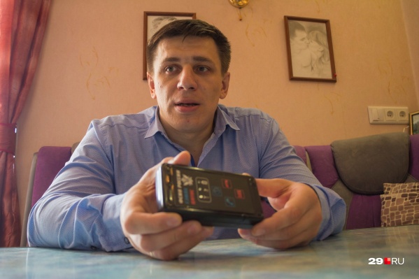 Андрей Боровиков показывает мобильное устройство, которое сообщает полиции, где он находится. Кроме него активист носит на ноге браслет Андрей Боровиков показывает мобильное устройство, которое сообщает полиции, где он находится. Кроме него активист носит на ноге браслет
