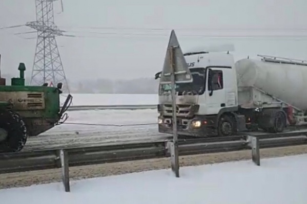 Трактор вызволял из снежного плена грузовики Трактор вызволял из снежного плена грузовики