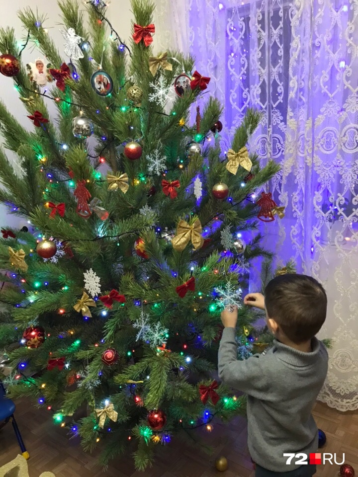 Угадайте, кто в доме главный по украшению праздничного деревца? Да, этот малыш, который бережно крепит игрушки на веточки, до которых может дотянуться
