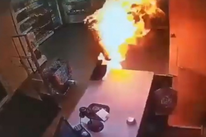 Это стоп-кадр видеозаписи с камер наблюдения: женщина пытается сбить пламя и выбегает из магазина