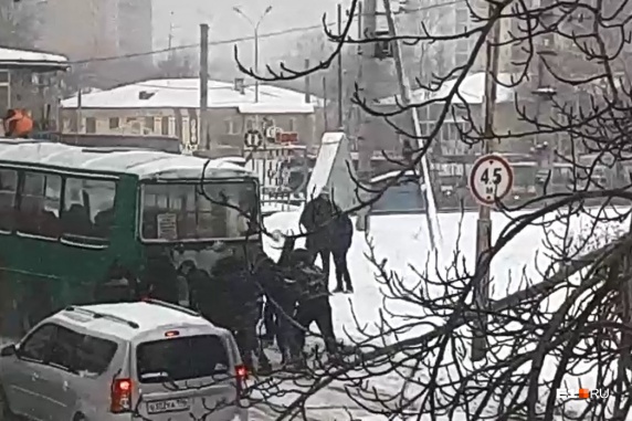 Пассажиры толкают автобус, чтобы преодолеть железнодорожный переезд Пассажиры толкают автобус, чтобы преодолеть железнодорожный переезд