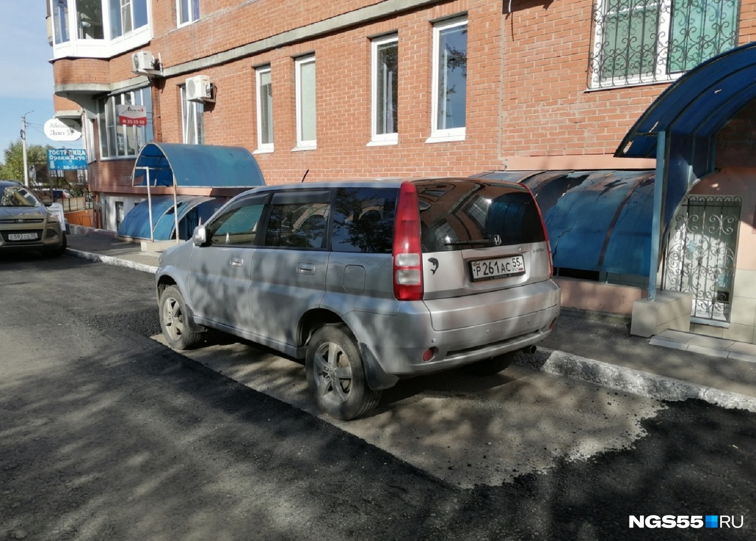 Дорожники рассказали, почему на Омской асфальт уложили вокруг припаркованной машины