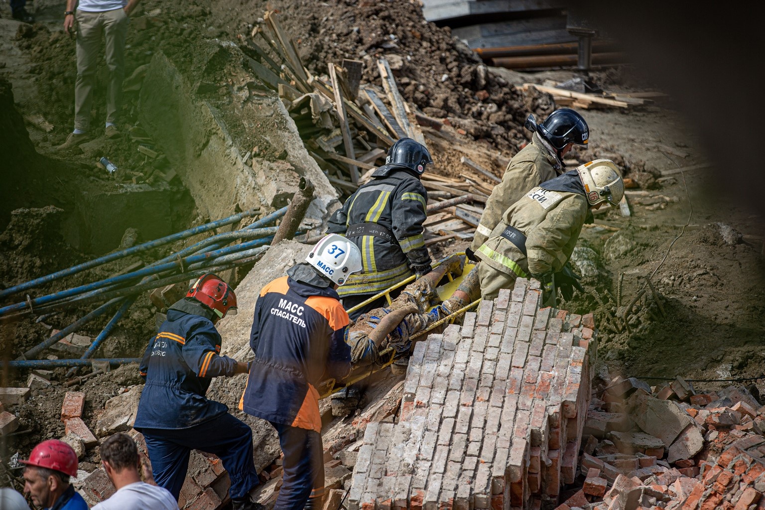 Разрушение команды. Человек под обломками здания. Спасение людей из завалов. Под обломками здания при землетрясении.