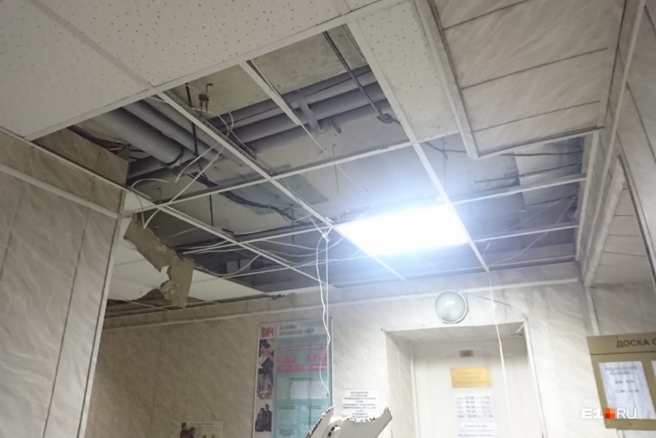Некоторые потолочные плиты упали на пол, другие повисли на проводах